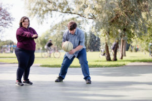 To unge mennesker i parken og spiller ball sammen.