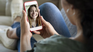 Ung kvinne snakker i mobiltelefonen med video