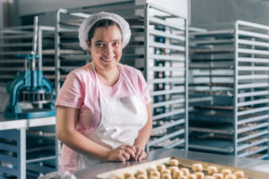 Kvinne som jobber i et bakeri.